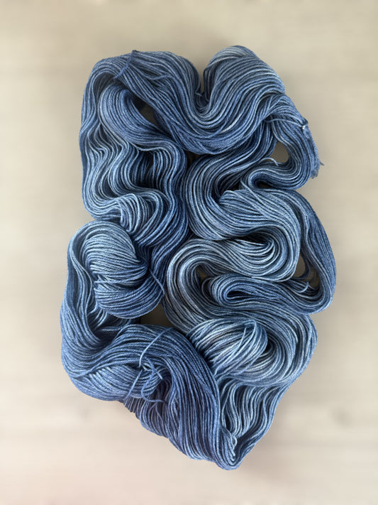 Hand-dyed "West Bay" ethically sourced merino wool yarn in serene blue tonal shades.