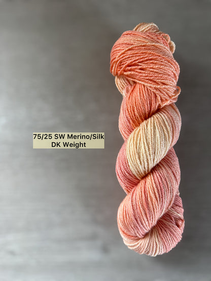 Hand-dyed Whispering Petals 75/25 SW Merino/Silk DK weight yarn in soft peach, ivory, and rose.