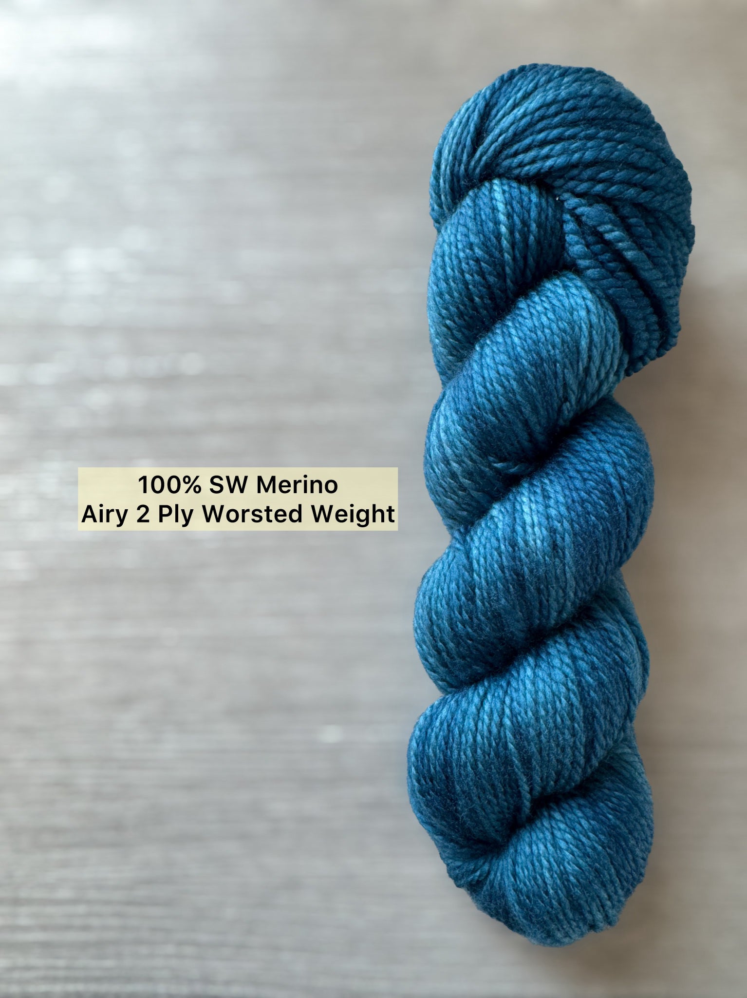 Hand-dyed "Bohemian Bluegrass" marine teal and blue ethically sourced Merino wool yarn skein.