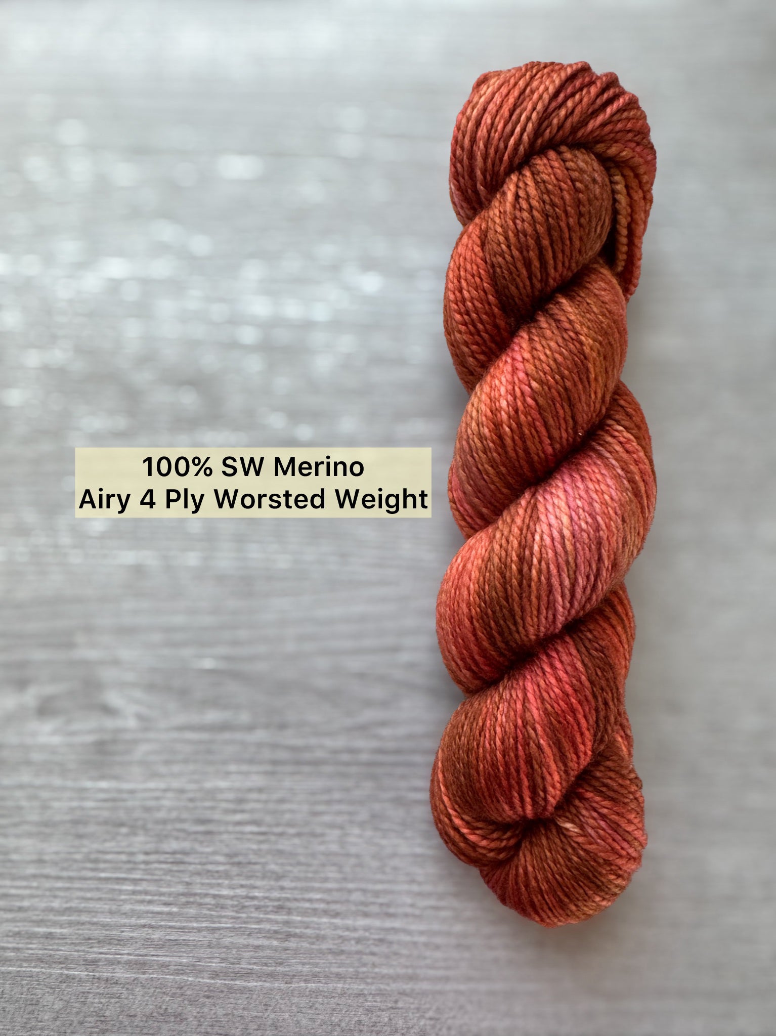 Hand-dyed "Memories Of Moab" ethically sourced merino wool yarn in rich reds, burnt orange, and rustic brown.