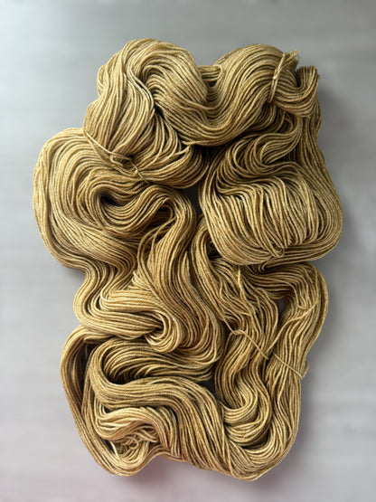 Ethically sourced "Adirondack Chair" hand-dyed merino wool yarn in warm golden tones.
