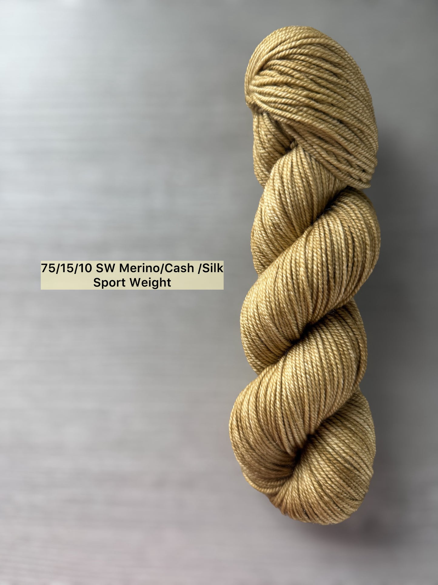 Ethically sourced "Adirondack Chair" hand-dyed sport weight merino wool yarn in warm golden tones.