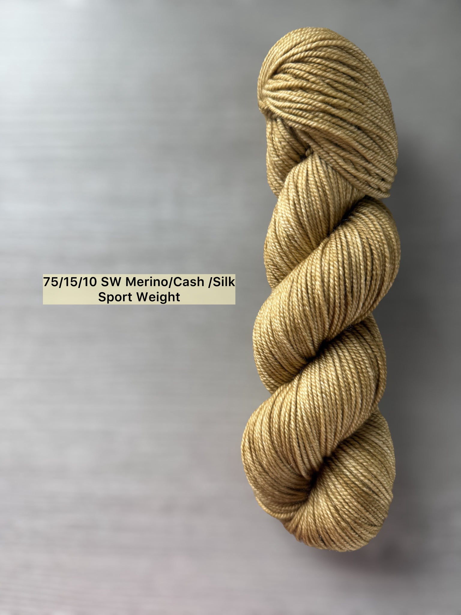 Ethically sourced "Adirondack Chair" hand-dyed sport weight merino wool yarn in warm golden tones.