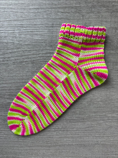 Striped pink and green sock on a gray background