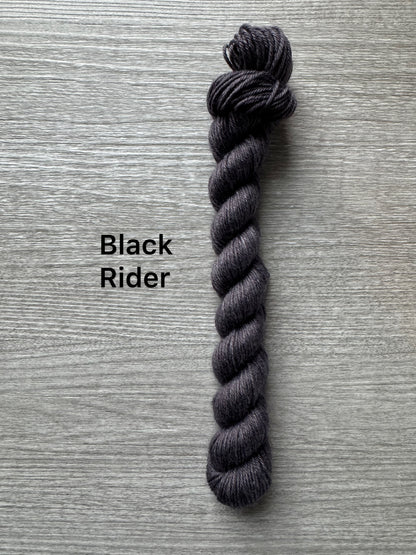 Dark gray skein of yarn labeled 'Black Rider' on a textured gray background