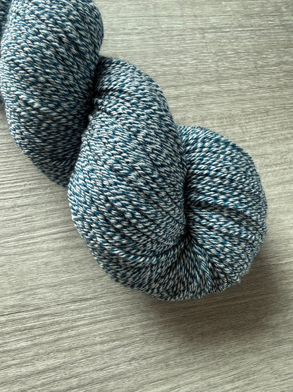 Hand-dyed "Bohemian Bluegrass" marine teal and blue merino wool yarn skein, ethically sourced.