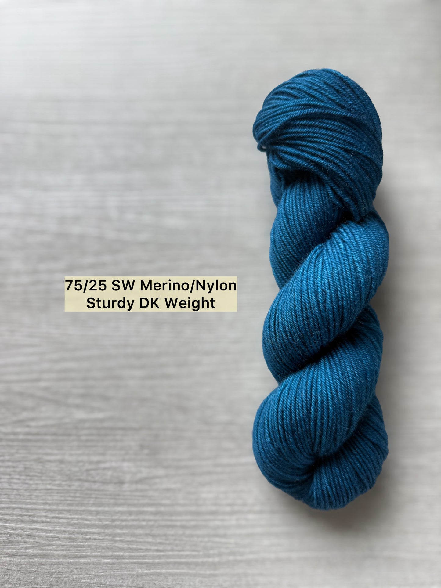 Hand-dyed "Bohemian Bluegrass" marine teal Merino wool yarn skein, ethically sourced.