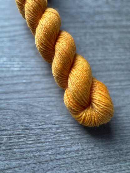 Yellow skein of yarn on a gray surface
