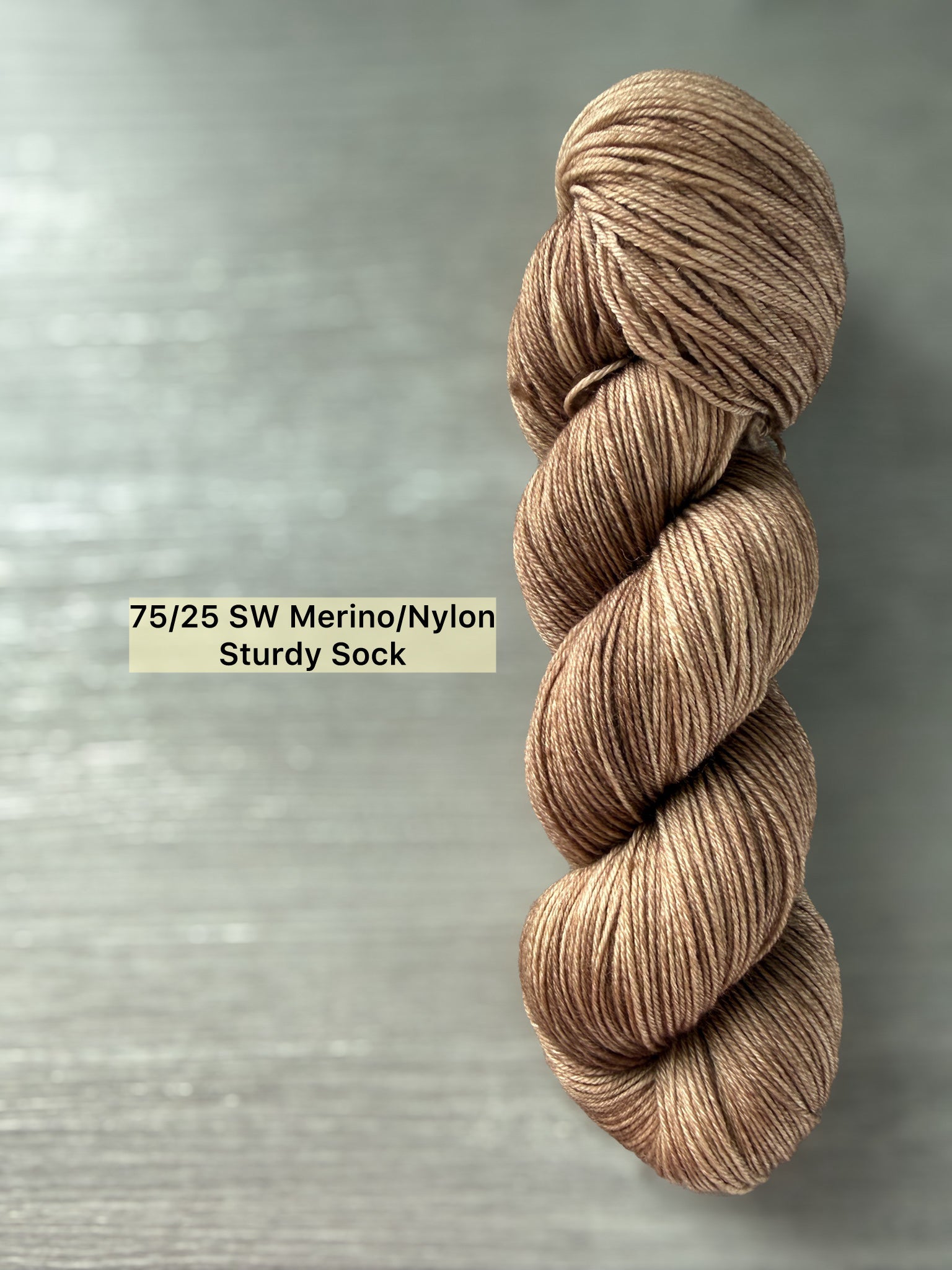 Ethically sourced "Lake House" hand-dyed merino wool yarn in soft and medium browns.
