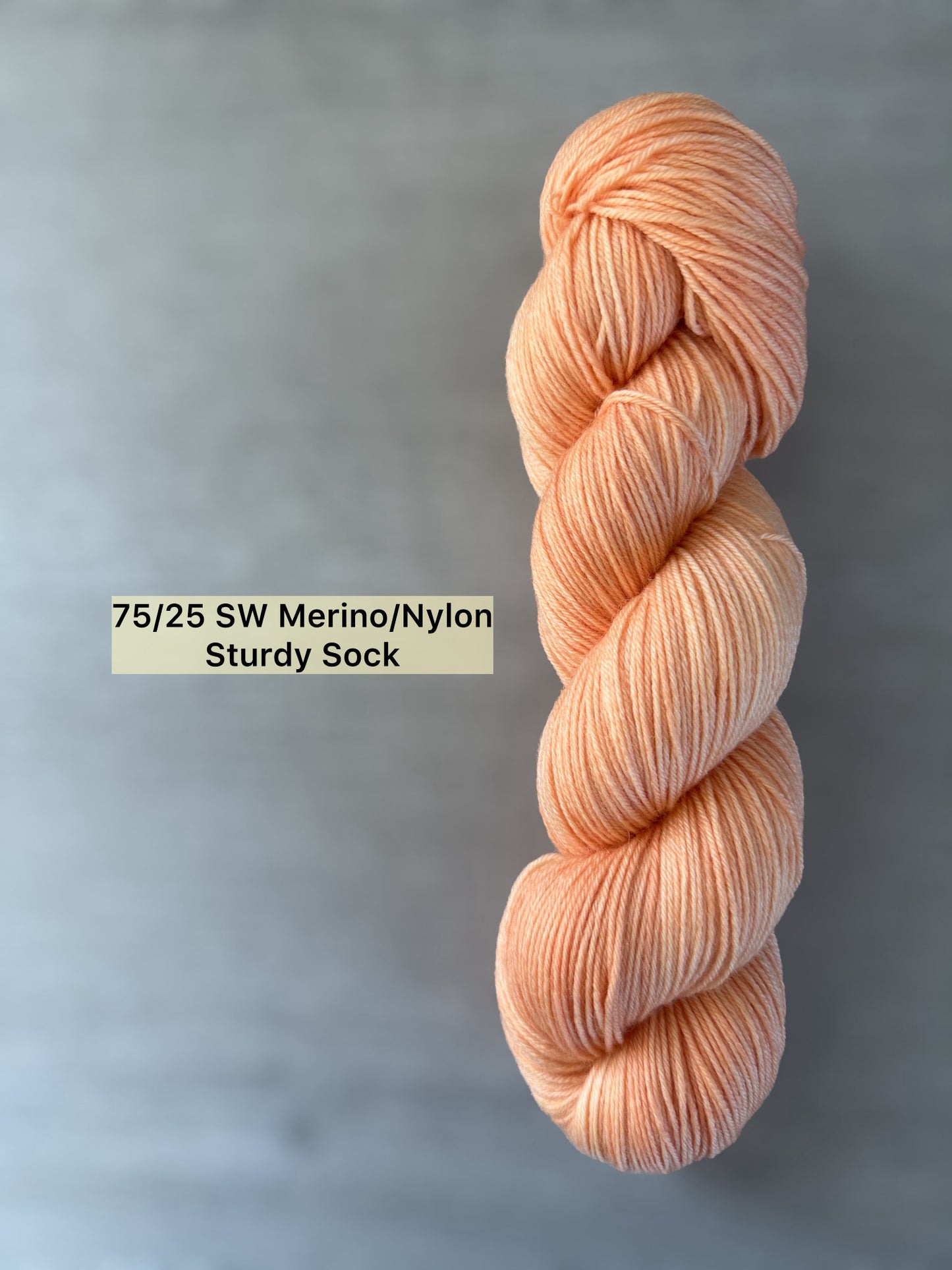 Ethically sourced, hand-dyed "Melon Dollar Smile" merino wool yarn in a vibrant coral-peach hue.