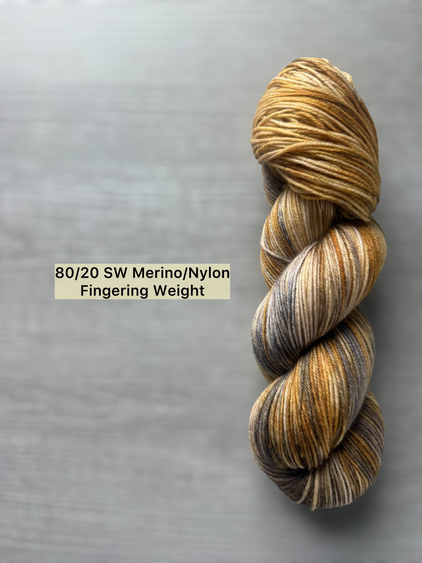Hand-dyed Mesa merino wool yarn, variegated with beige, charcoal, taupe, and toasted ocher. Ethically sourced.