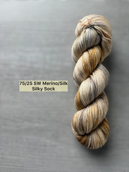 Hand-dyed Mesa ethically sourced merino/silk yarn in beige, charcoal, taupe, and toasted ocher.