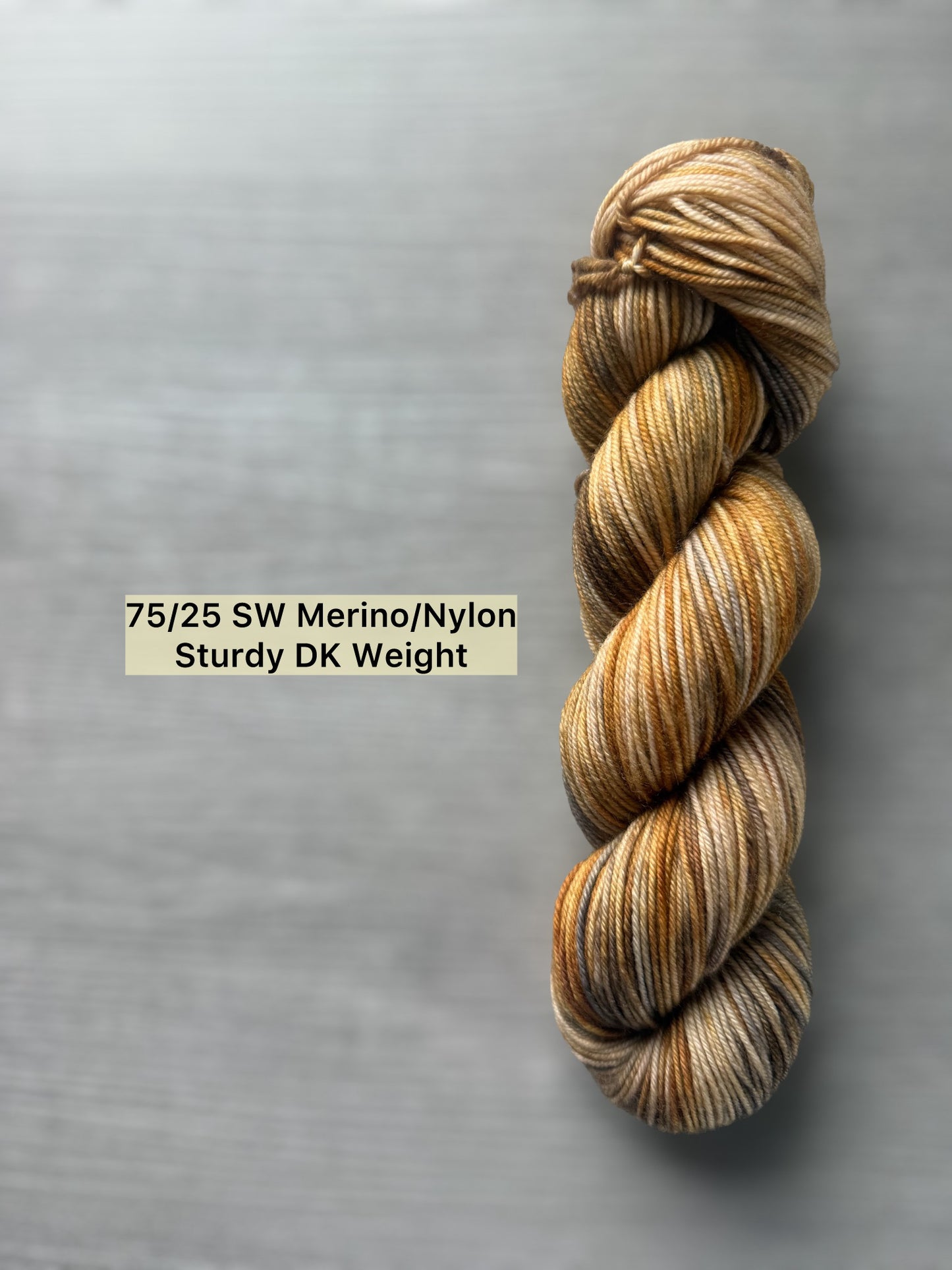 Hand-dyed Mesa Merino wool yarn with beige, charcoal, taupe, and ocher tones. Ethically sourced.