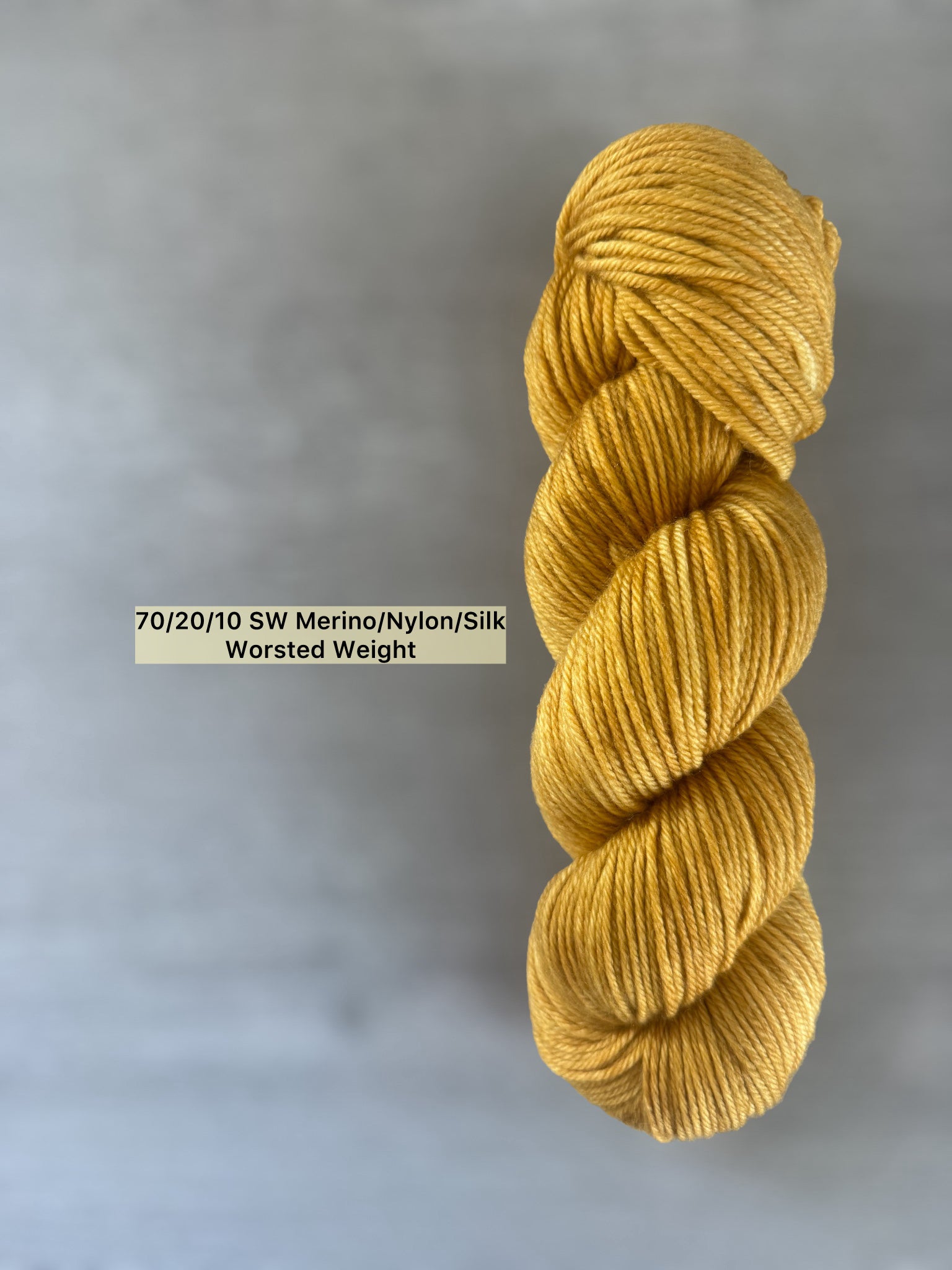 Hand-dyed "None Of Your Beeswax" golden yellow merino wool blend yarn, worsted weight.