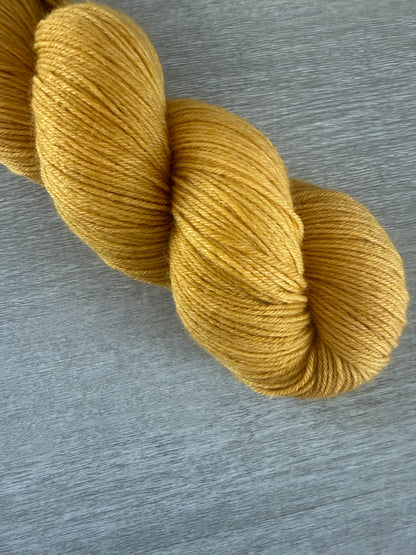 Golden yellow, hand-dyed "None Of Your Beeswax" ethically sourced merino wool yarn skein.