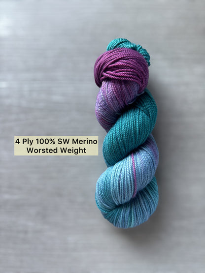 A skein of yarn purple and blue, on a gray background with text indicating yarn weight.
