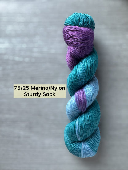Turquoise and purple yarn skein on a gray background with text indicating composition and type.