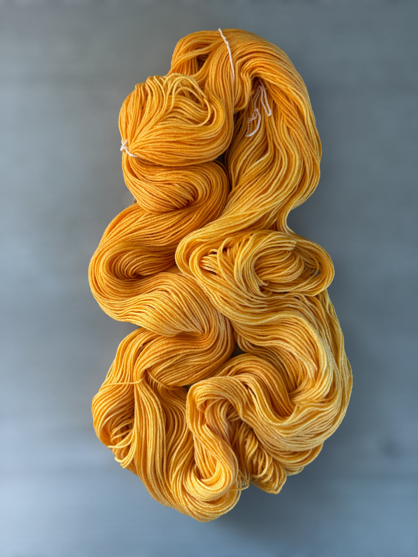 Soleil bright golden yellow hand-dyed ethically sourced merino wool yarn skein, radiating warmth.