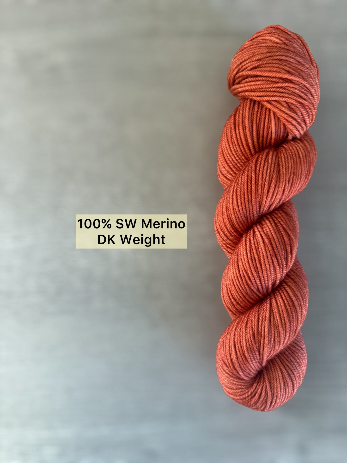 Hand-dyed terracotta 100% SW Merino DK weight yarn, ethically sourced, with warm reddish-brown tones.