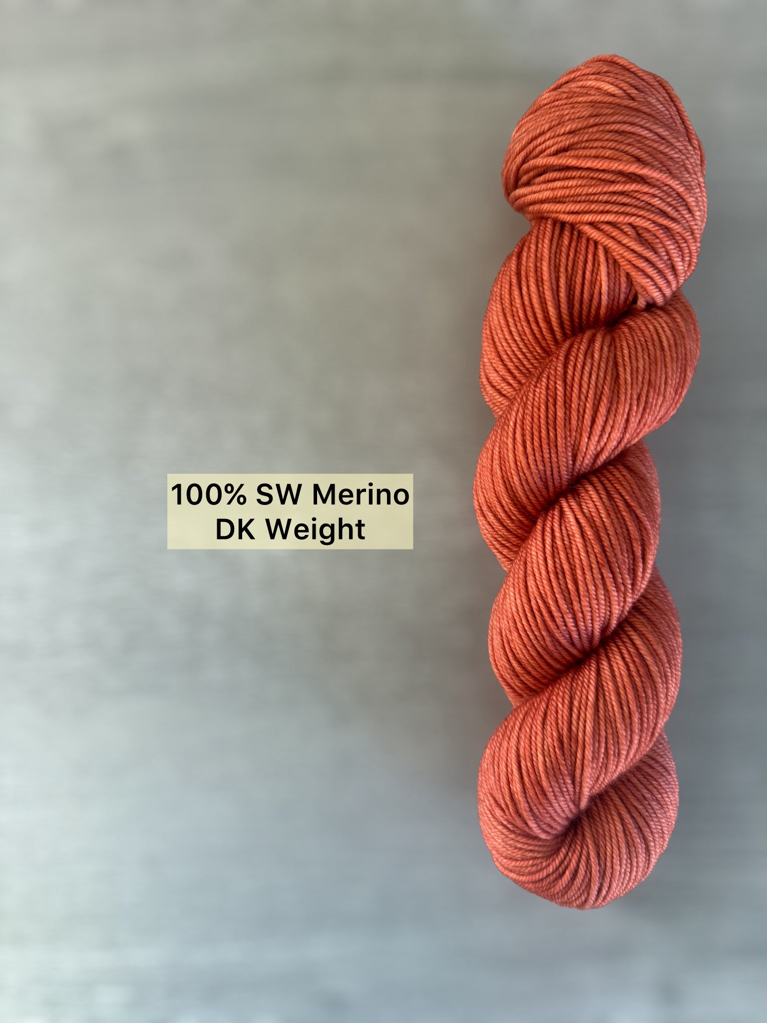 Hand-dyed terracotta 100% SW Merino DK weight yarn, ethically sourced, with warm reddish-brown tones.