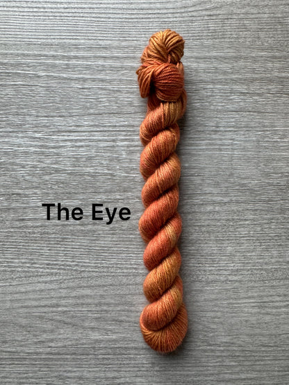 orange skein of yarn labeled 'The Eye' on a gray background