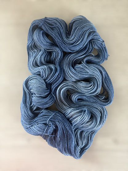Hand-dyed "West Bay" ethically sourced merino wool yarn in serene blue tonal shades.