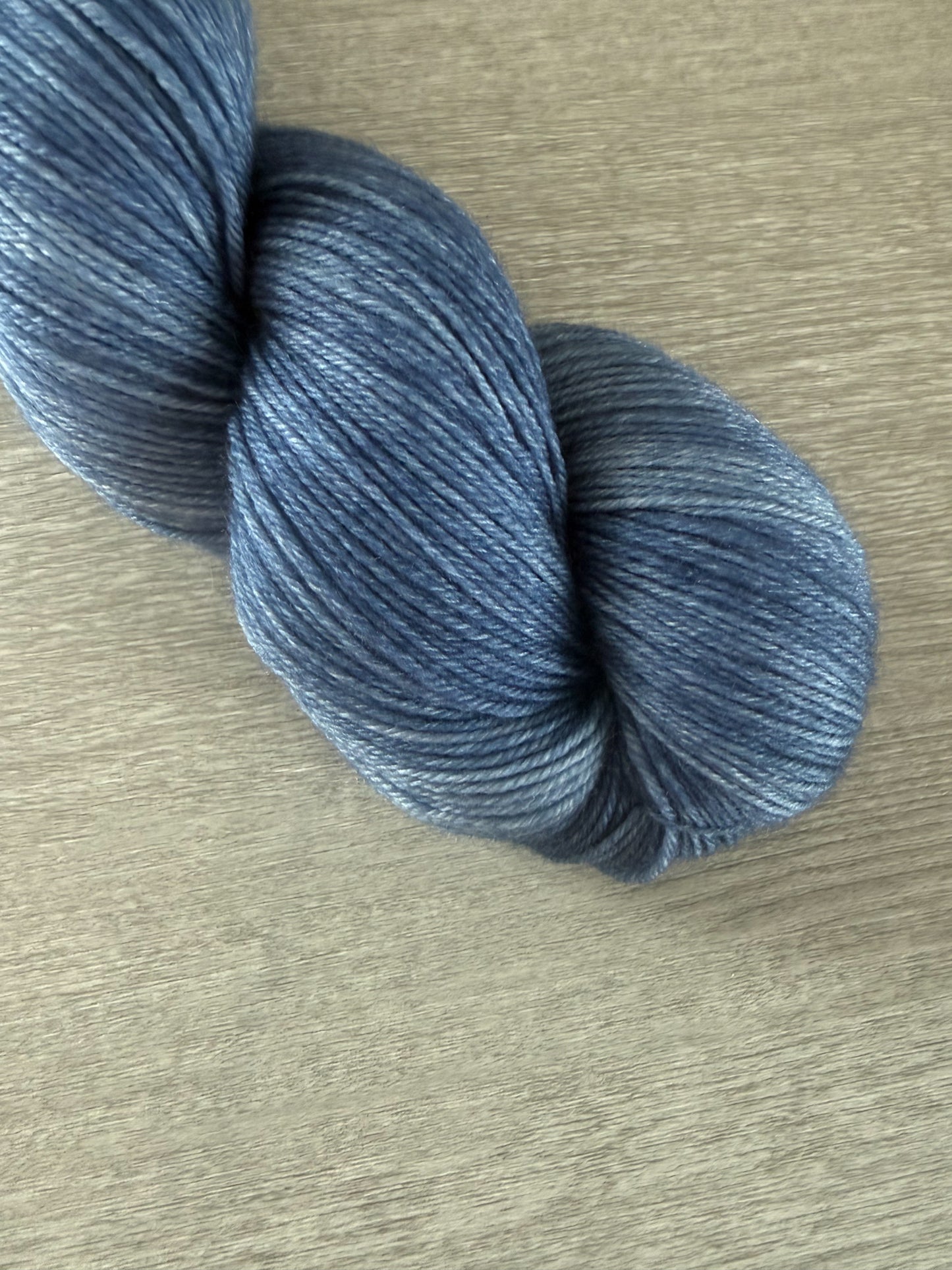 Hand-dyed West Bay artisan merino wool yarn in serene blue tonal shades, ethically sourced.