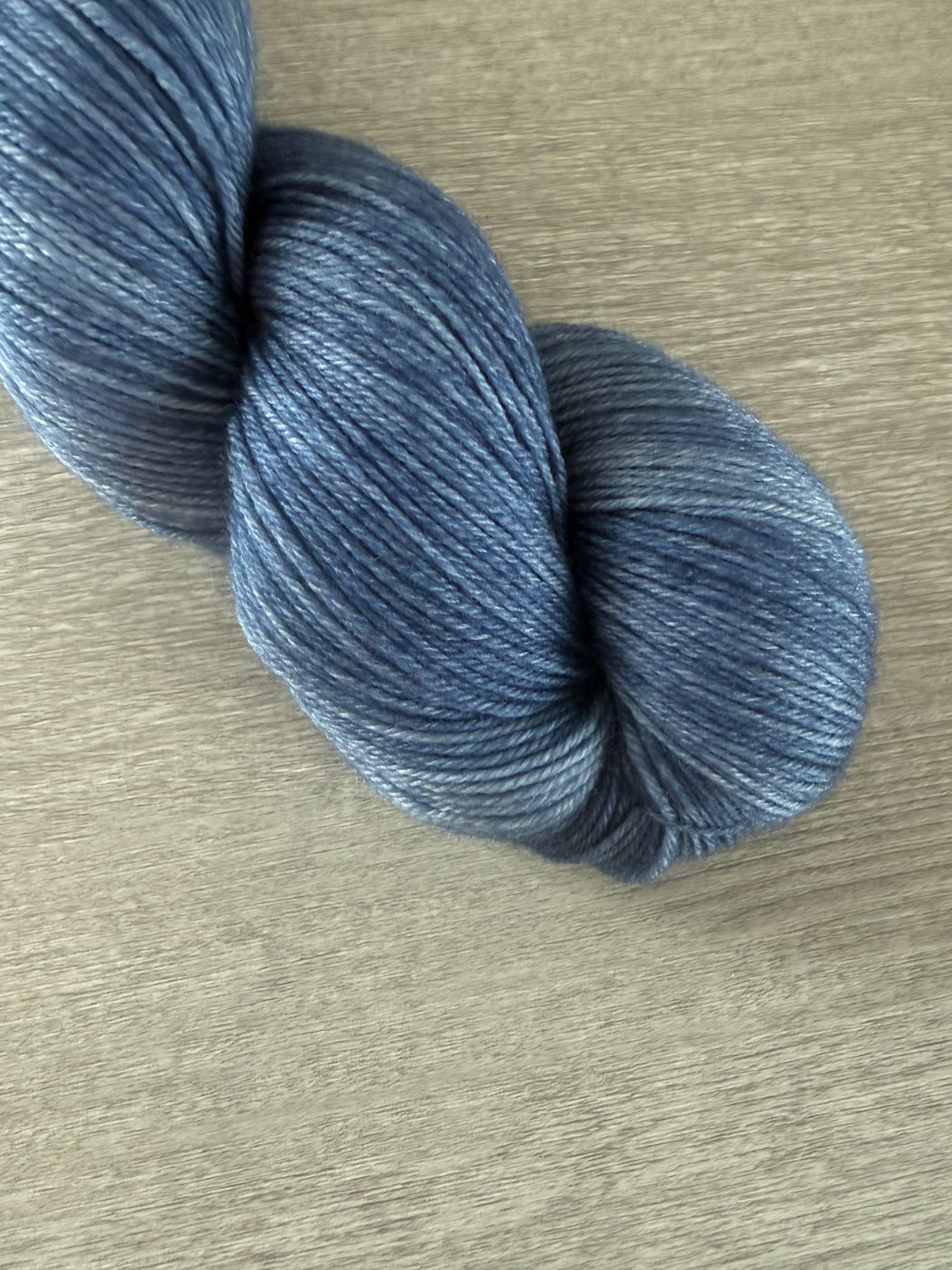 Hand-dyed West Bay artisan merino wool yarn in serene blue tonal shades, ethically sourced.