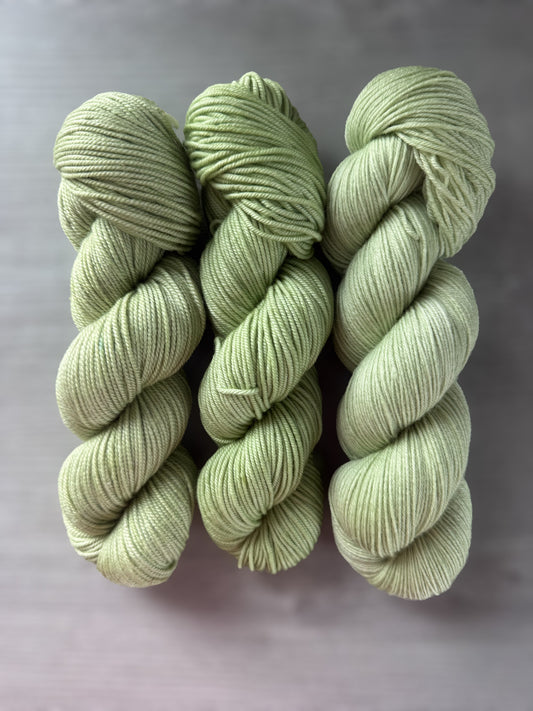 Three skeins of "Too Many Margaritas" vibrant lime green, ethically sourced merino wool yarn.