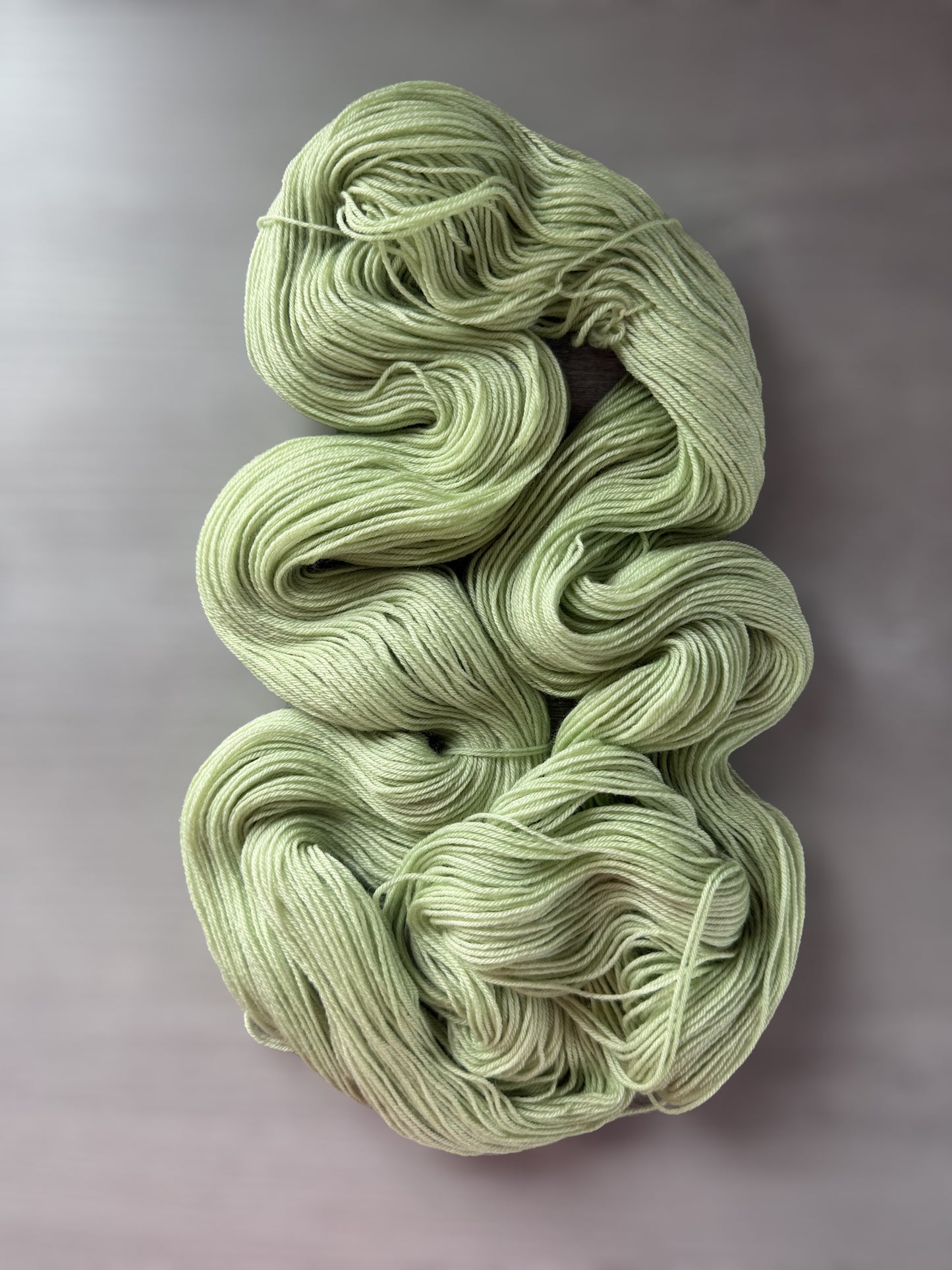 Vibrant lime green "Too Many Margaritas" hand-dyed ethically sourced merino wool yarn skein.