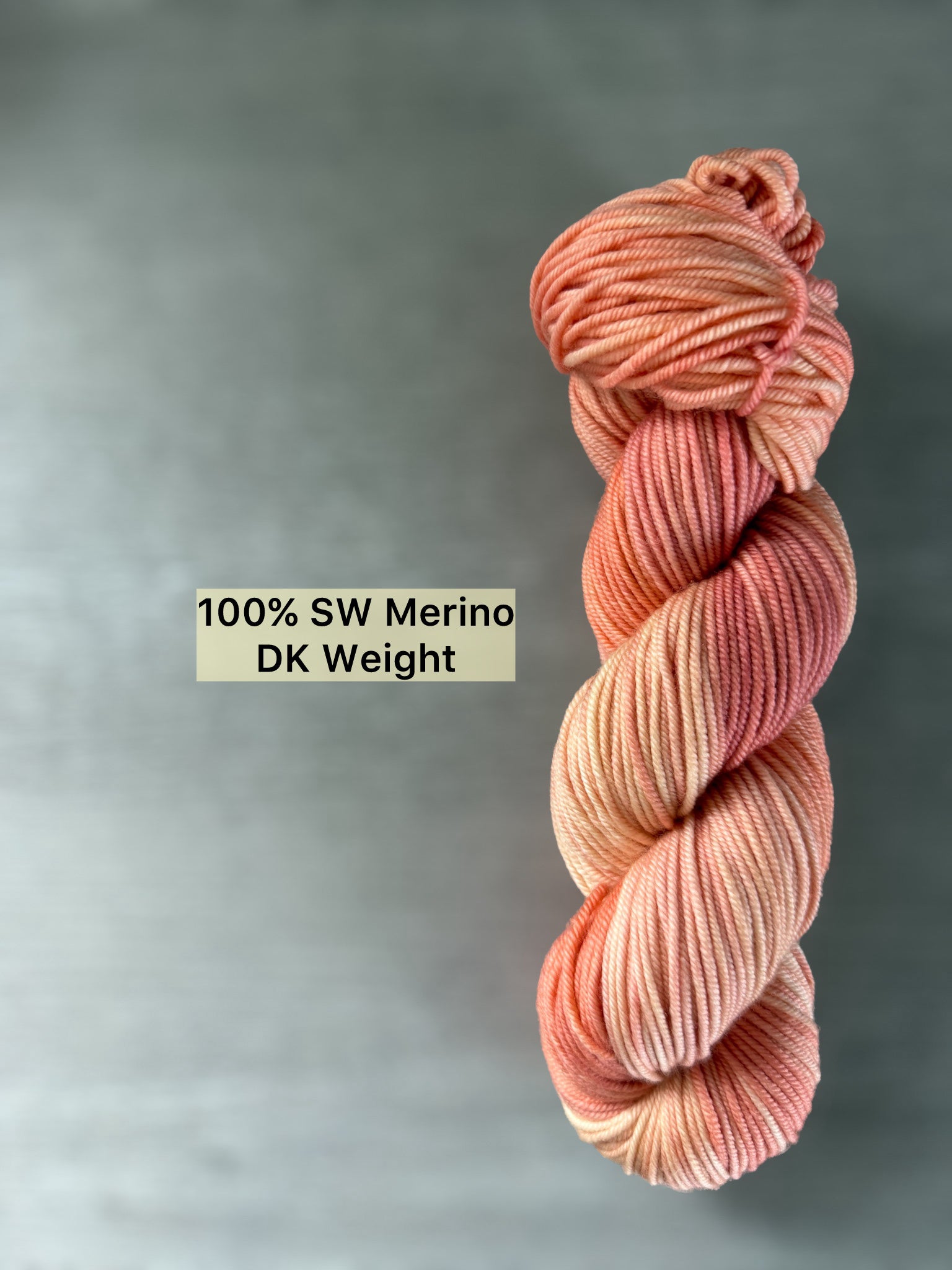 Ethically sourced hand-dyed merino wool yarn in soft peach, ivory, and rose hues.