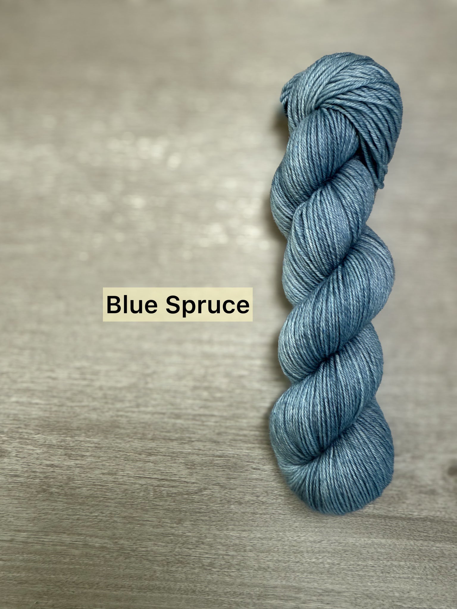 Ethically sourced Blue Spruce hand-dyed merino wool and nylon fingering weight yarn skein.