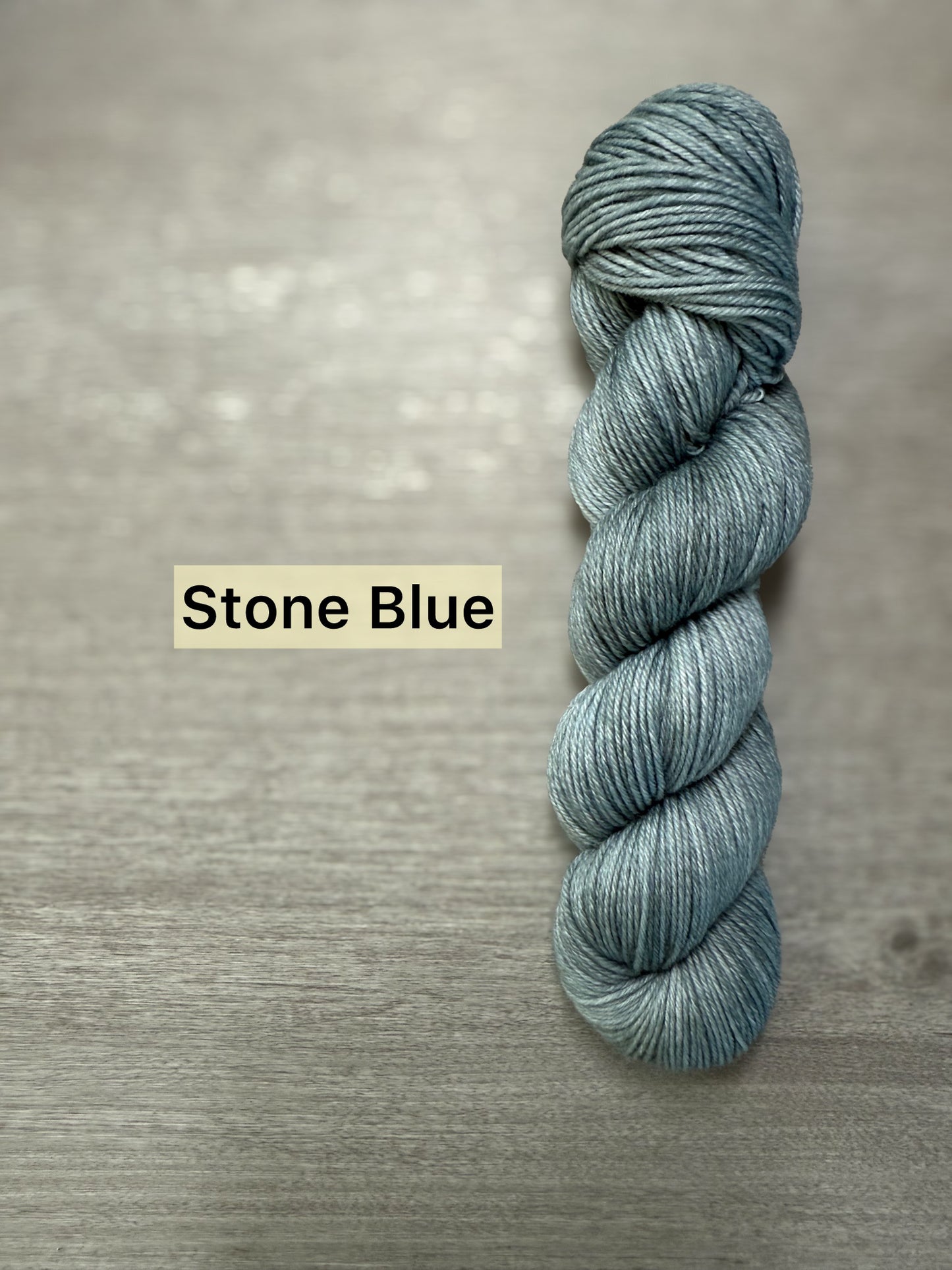 Ethically sourced "Stone Blue" hand-dyed merino wool and nylon fingering weight sock yarn skein.