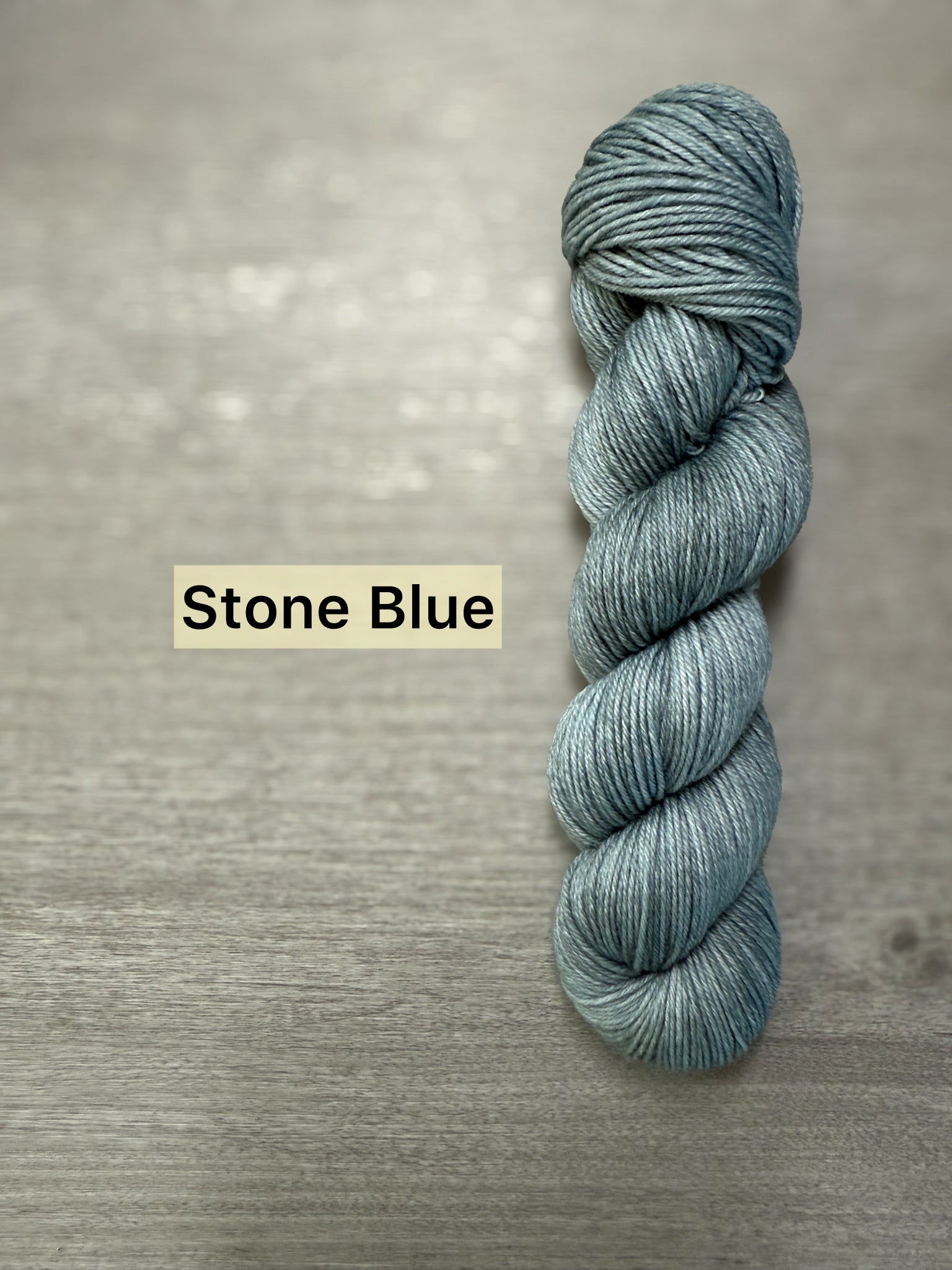 Ethically sourced "Stone Blue" hand-dyed merino wool and nylon fingering weight sock yarn skein.